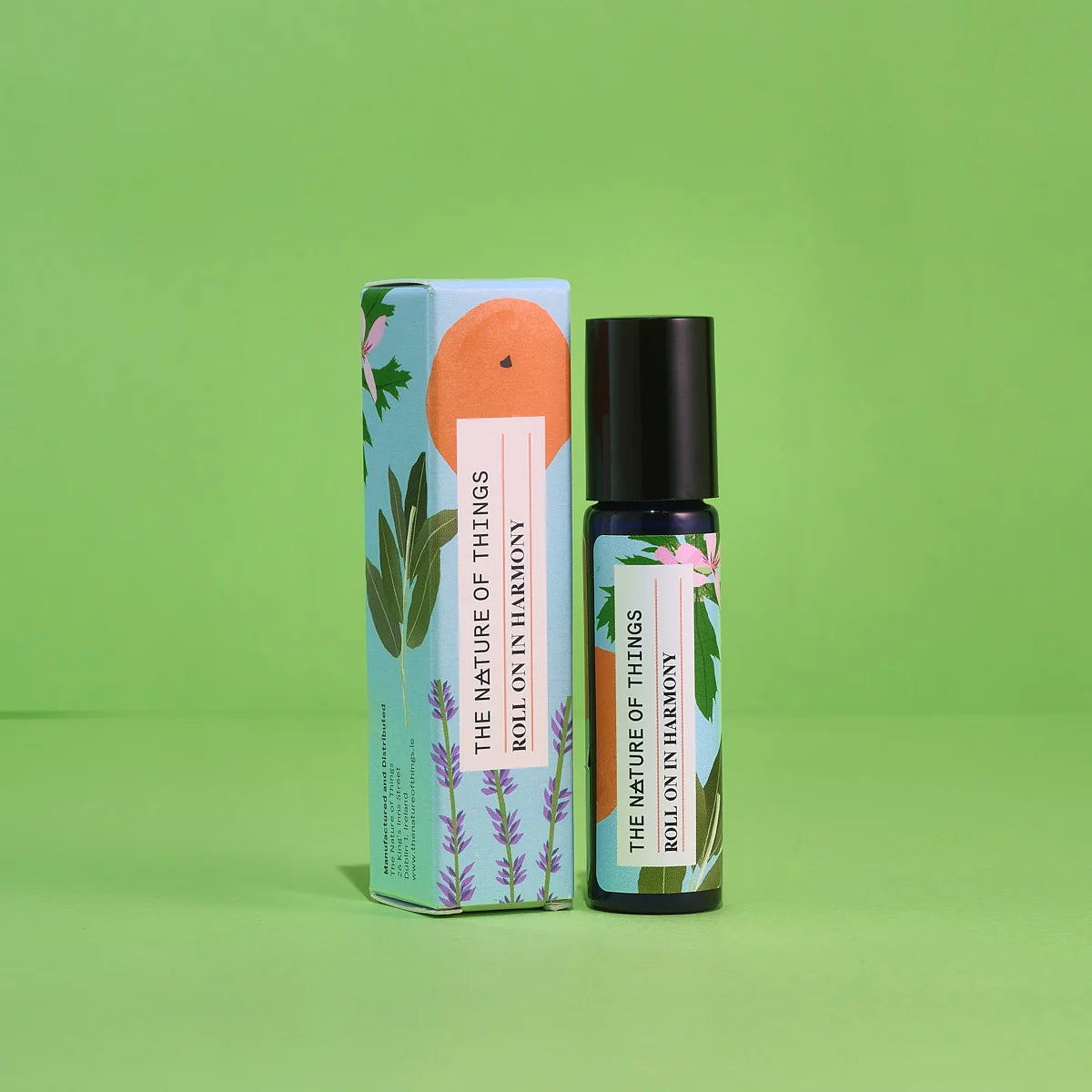 Blauer 10-ml-Roll-On und dazugehörige hellblaue Umverpackung mit Orangen- und Lavendel-Illustration vor einem grünen Hintergrund.