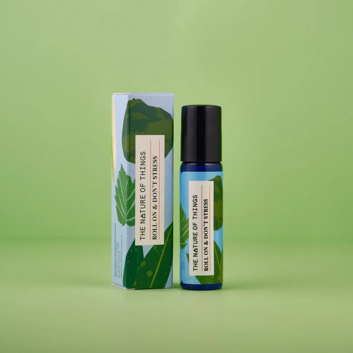 Blauer 10-ml-Roll-On und dazugehörige hellblaue Umverpackung mit grünen Blatt-Illustrationen vor einem grünen Hintergrund.