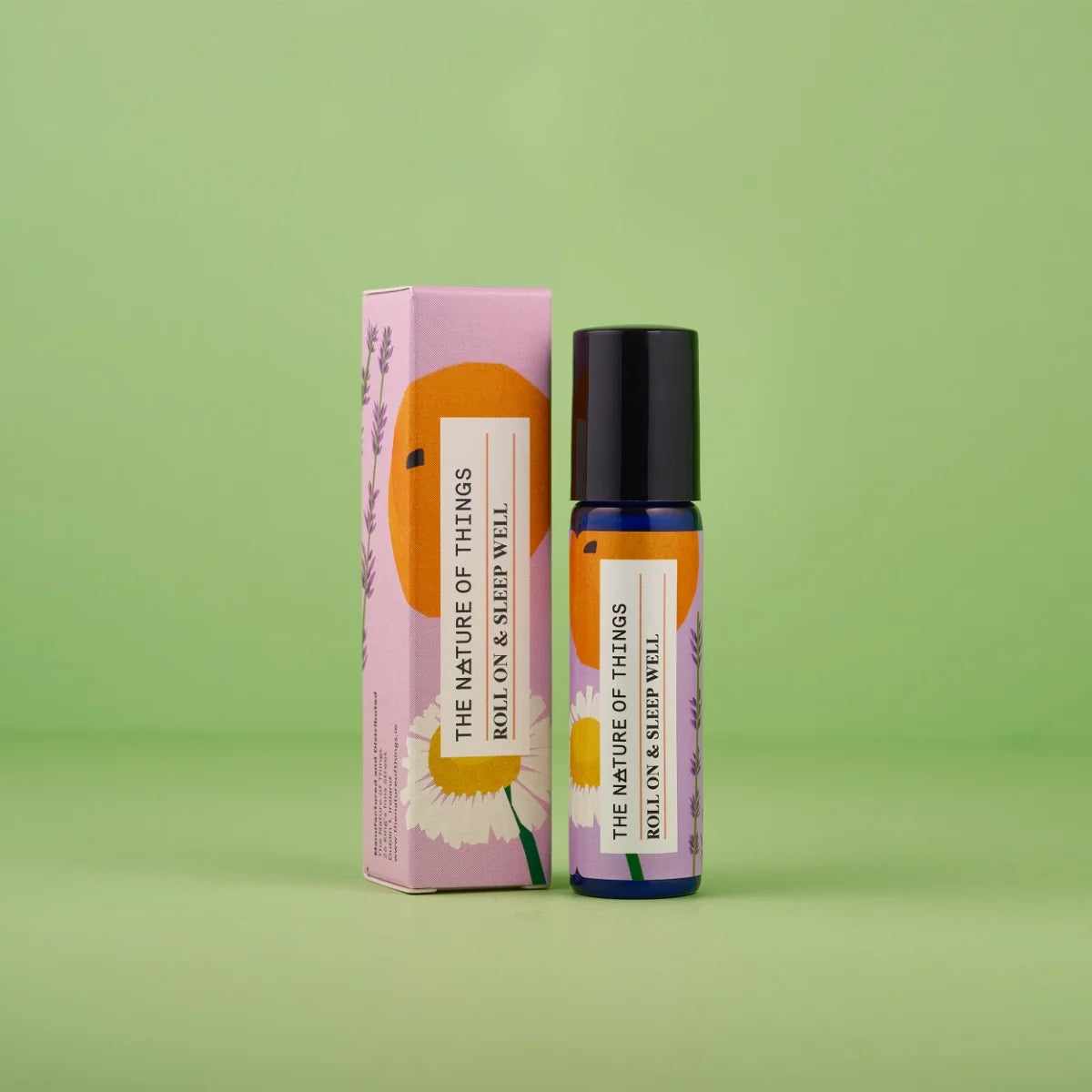 Blauer 10-ml-Roll-On und dazugehörige rosa Umverpackung mit Orangen- und Gänseblümchen-Illustrationen vor einem grünen Hintergrund.