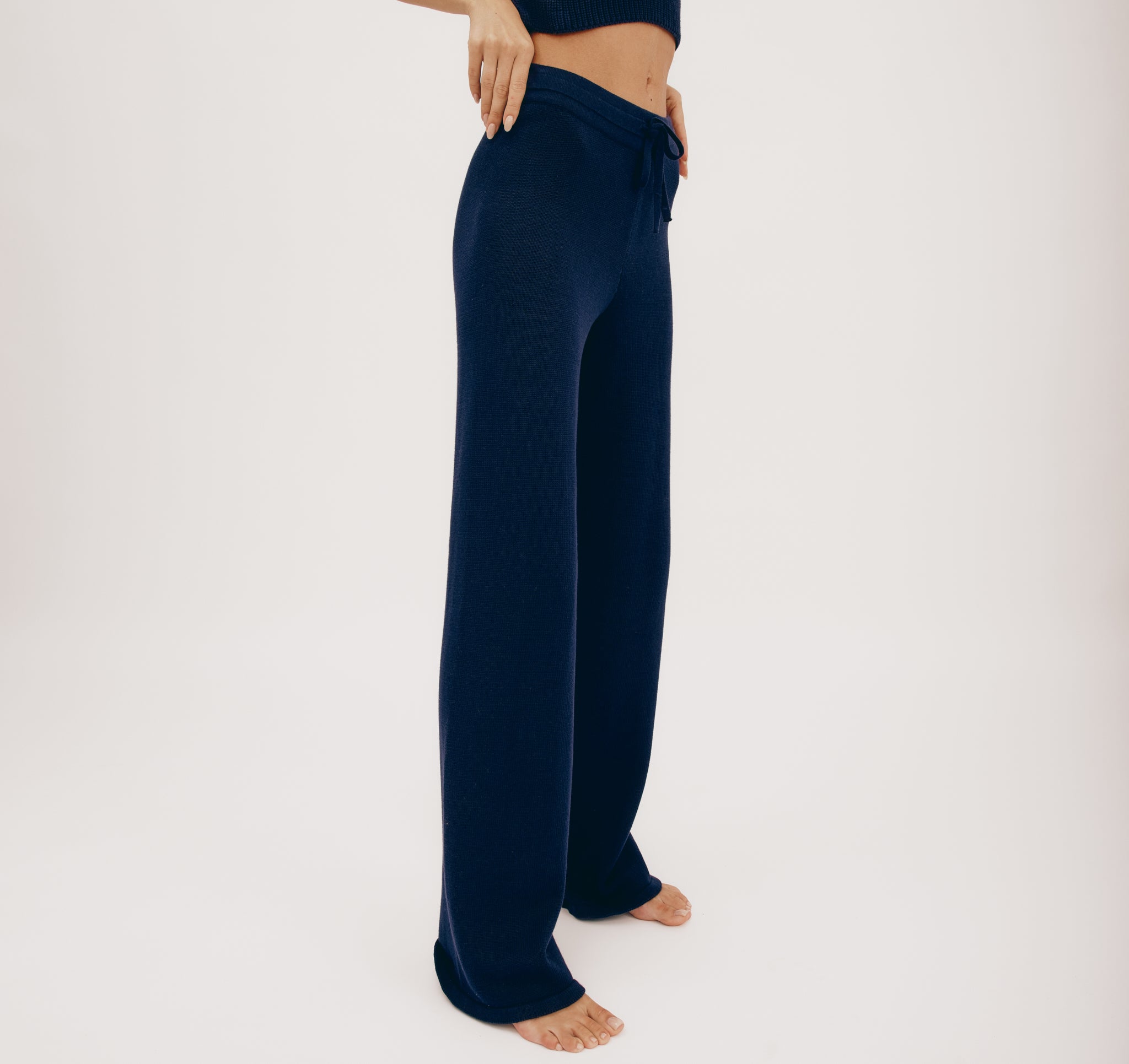 Dunkelblaue Strickhose "True Knit Wide Leg" mit weitem Bein und Kordelzug am hohen Bund, gezeigt in zwei Ansichten von vorne und hinten vor hellem Hintergrund.