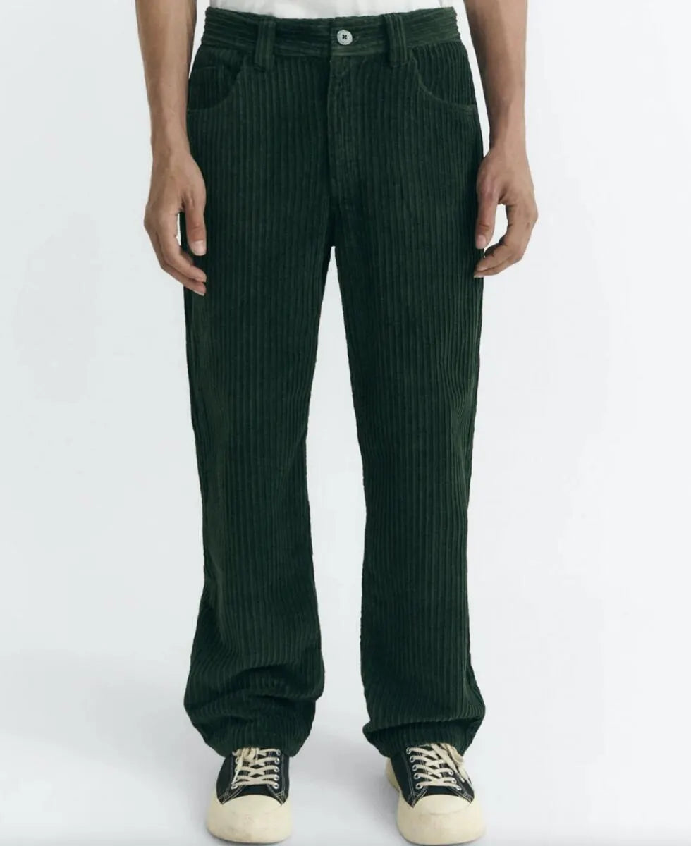 Dunkelgrüne Cordhose "David" von Thinking Mu aus feinem Cord-Stoff mit klassischen Taschen und Gürtelschlaufen vor hellem Hintergrund.