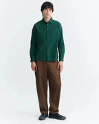 Dunkelgrünes Microcord-Hemd "Anto" von Thinking Mu mit Button-Down-Kragen, Knopfleiste und Brusttasche vor hellem Hintergrund.