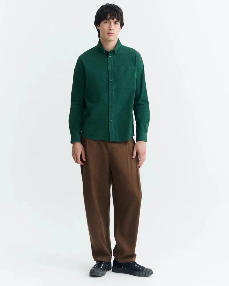 Dunkelgrünes Microcord-Hemd "Anto" von Thinking Mu mit Button-Down-Kragen, Knopfleiste und Brusttasche vor hellem Hintergrund.