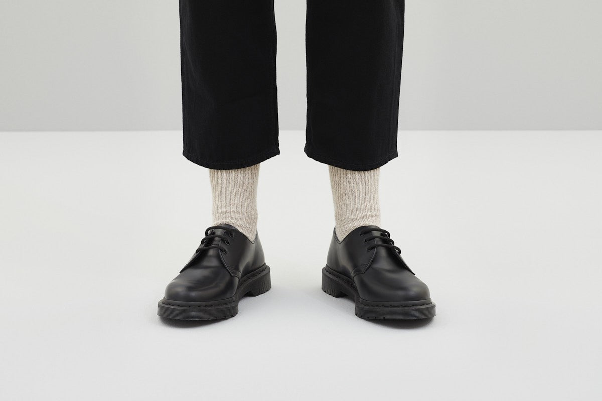 Ein Paar melierte sandfarbene Stricksocken aus Merinowolle von Ferdinand vor weißem Hintergrund. koblenz trust