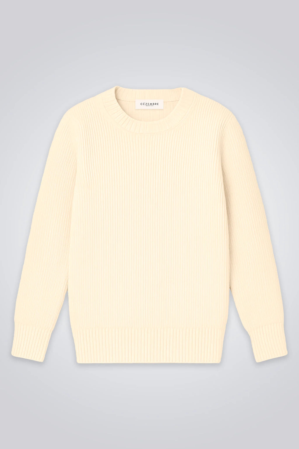 Ein klassischer Wollpullover in hellem Ecru mit feiner Rippstruktur und Rundhalsausschnitt auf hellem Hintergrund.
