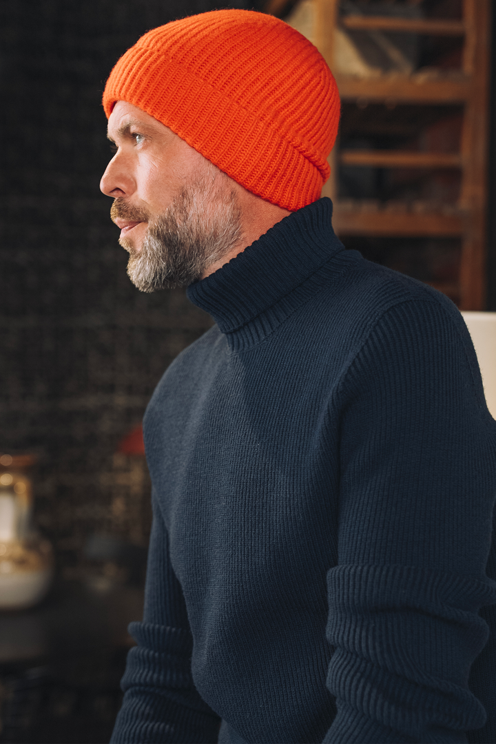 Ein klassischer dunkelblauer Rollkragenpullover aus Wolle mit feiner Rippstruktur vor hellem Hintergrund. koblenz