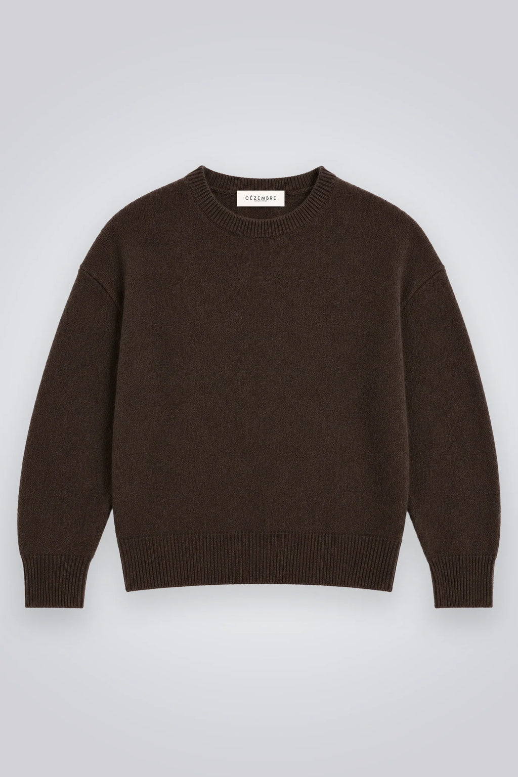 Eine Person trägt einen braunen Kaschmir-Merino-Pullover mit Rundhalsausschnitt 