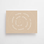 Eine Postkarte im sandfarbenen Ton mit einer feinen weißen Spirale und kreisförmig angeordnetem englischen Text über persönliches Wachstum.