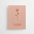 Eine altrosafarbene Mini-Karte mit einer feinen Rosen-Illustration und dem englischen Schriftzug „YOU ARE HERE TO BLOSSOM“ vor weißem Hintergrund.