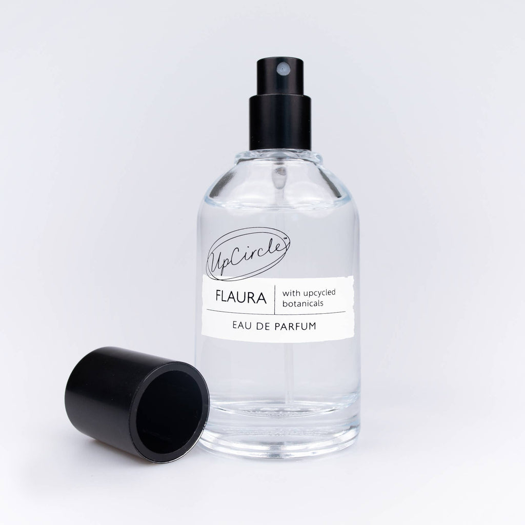 Flaura Parfumflasche mit dekorativen Vanilleschoten und Zimtstangen.