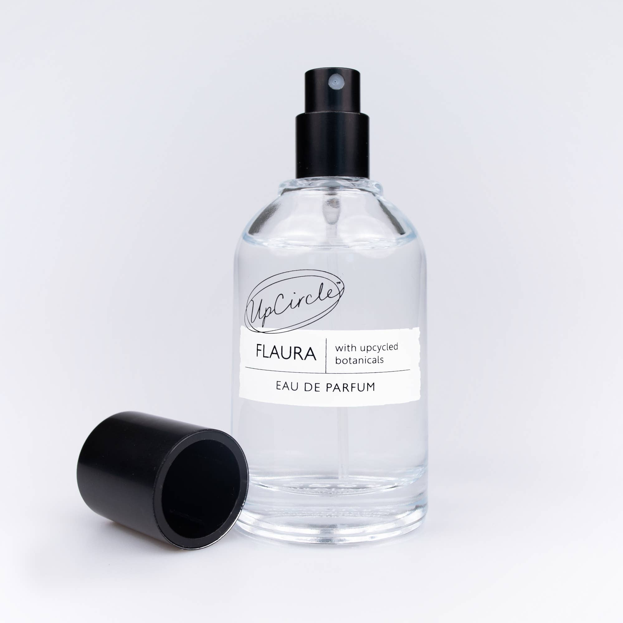 Flaura Parfumflasche mit dekorativen Vanilleschoten und Zimtstangen.