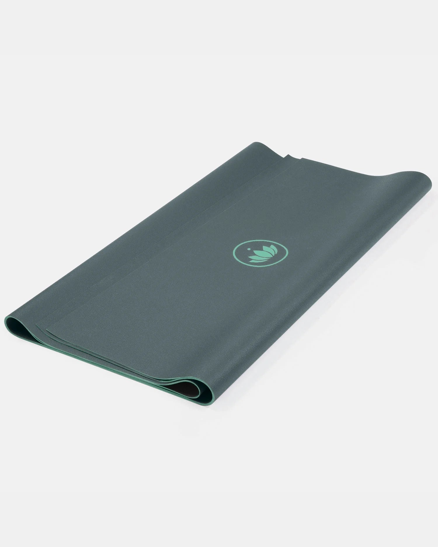 Gefaltete grüne Yogamatte "Arise Travel" in Balsam Green mit Lotus-Logo vor hellem Hintergrund.