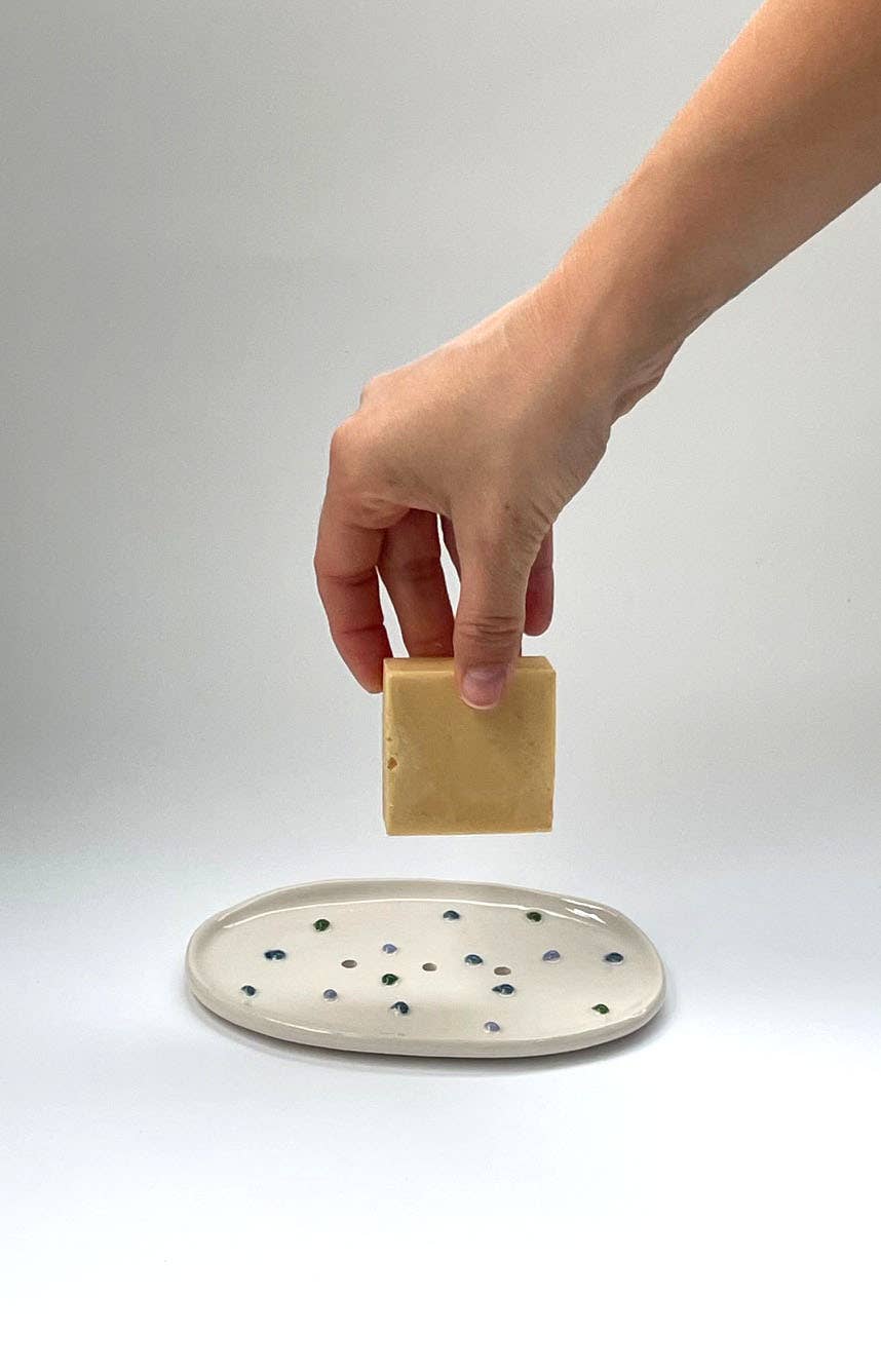 Handgefertigte weiße Keramik Seifenschale mit bunten, erhabenen Punkten und einem zentralen Ablaufloch.