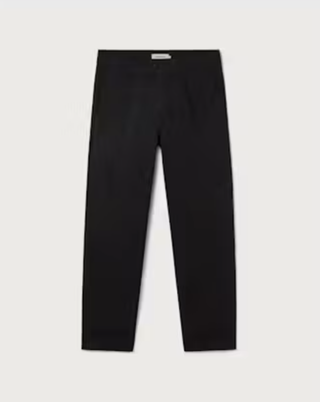 Klassische schwarze Hose "Wotan" von Thinking Mu aus Bio-Baumwolle in gerader Passform vor hellem Hintergrund.