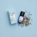 Kleine blaue 12-ml-Flasche des Essential Oil Lavender von The Nature of Things und dazugehörige hellblaue Umverpackung mit Lavendel-Illustrationen vor einem hellblauen Hintergrund.