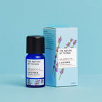 Kleine blaue 12-ml-Flasche des Essential Oil Lavender von The Nature of Things und dazugehörige hellblaue Umverpackung mit Lavendel-Illustrationen vor einem hellblauen Hintergrund.