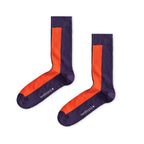 Ein Paar dunkelviolette Socken mit einem auffälligen orangen vertikalen Streifen auf der Vorderseite und dem Markenlogo auf der Fußsohle vor hellem Hintergrund.   