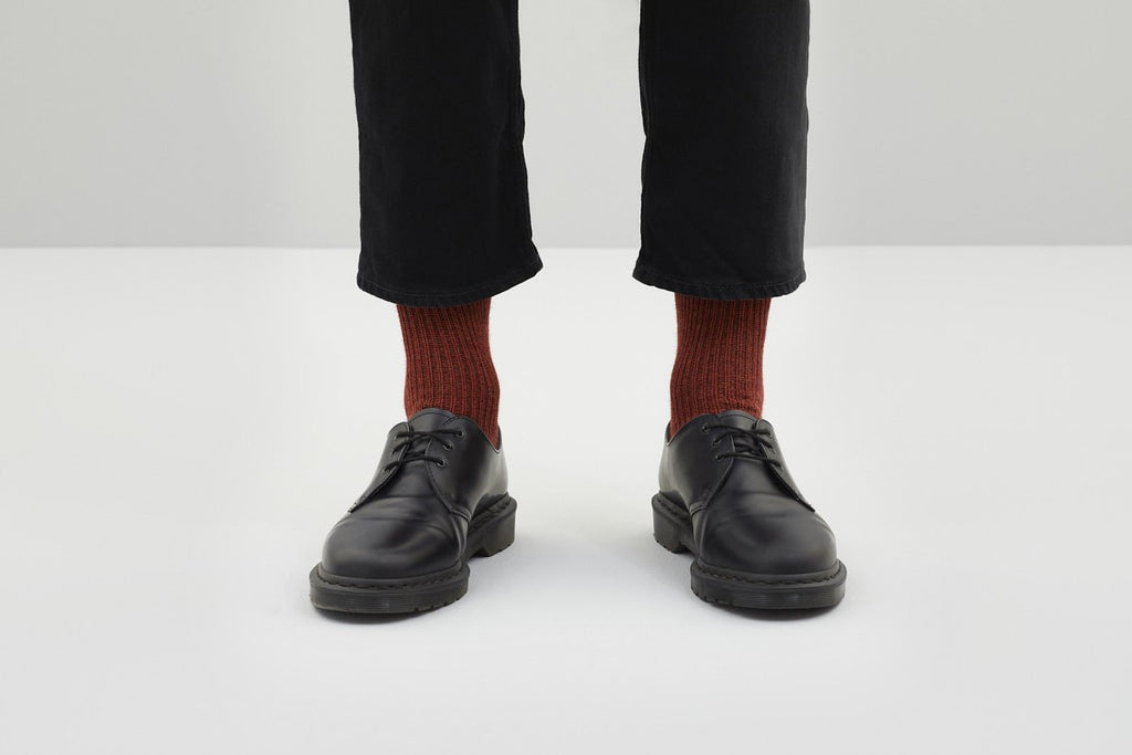 Koblenz; Ein Paar dicke, rustikal gestrickte Socken in Rostrot mit einem gerippten Bündchen. 