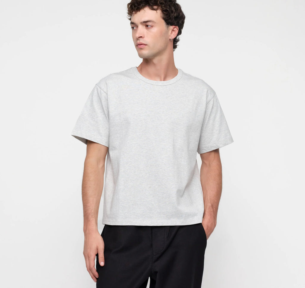 Männliches Model trägt ein graues True Extra Heavy Boxy Tee von organic basics in Misty Grey Melange mit kastenförmiger Passform.