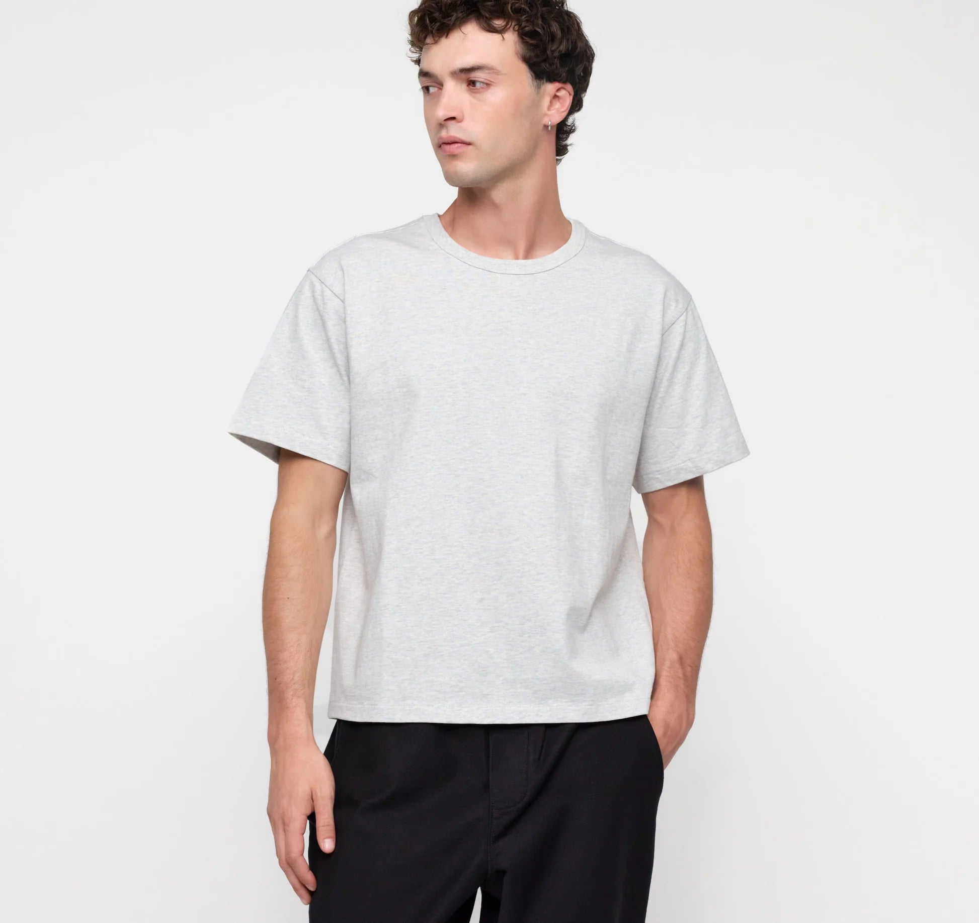 Männliches Model trägt ein graues True Extra Heavy Boxy Tee von organic basics in Misty Grey Melange mit kastenförmiger Passform.