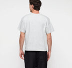 Männliches Model trägt ein graues True Extra Heavy Boxy Tee von organic basics in Misty Grey Melange mit kastenförmiger Passform.