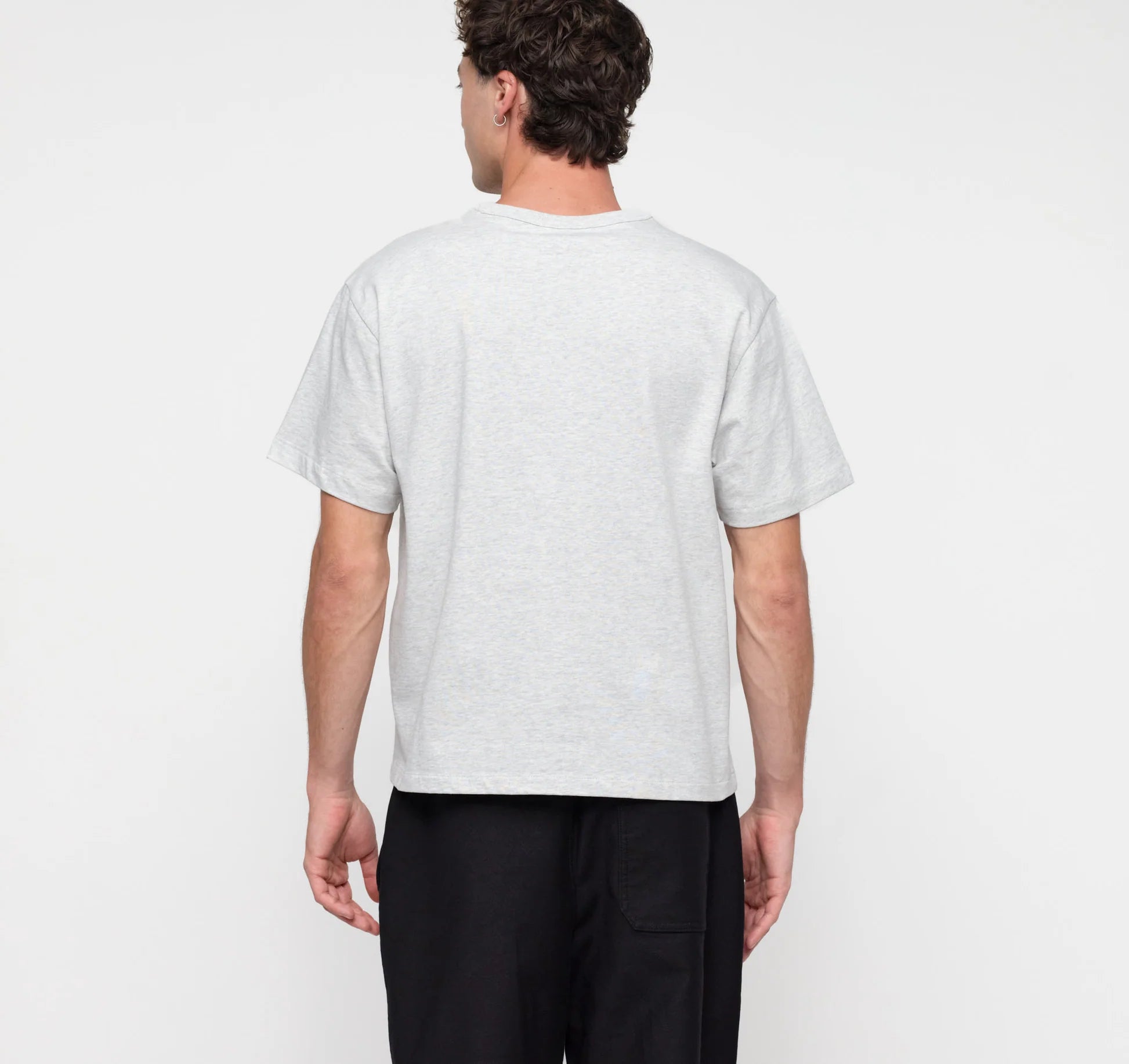 Männliches Model trägt ein graues True Extra Heavy Boxy Tee von organic basics in Misty Grey Melange mit kastenförmiger Passform.