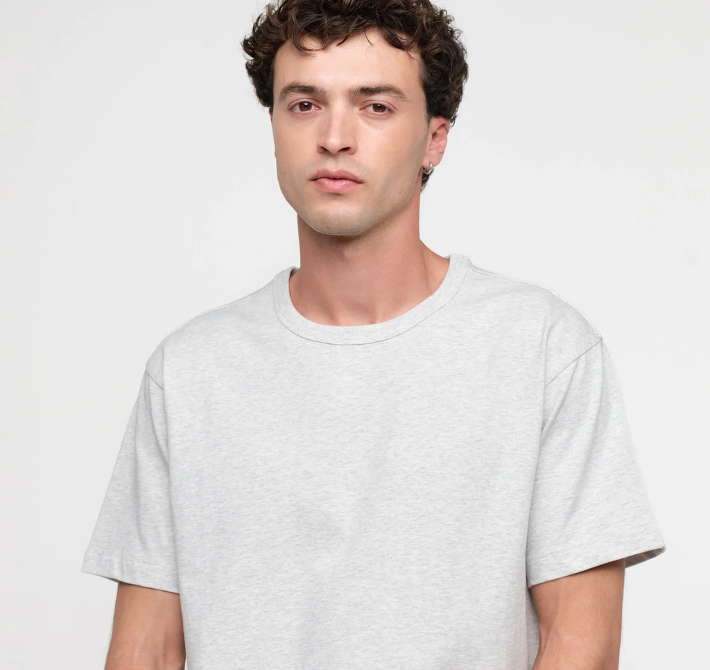 Männliches Model trägt ein graues True Extra Heavy Boxy Tee von organic basics in Misty Grey Melange mit kastenförmiger Passform.