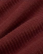Mahagonifarbene Cordhose "Hedda" aus 100% Bio-Baumwolle mit geradem Bein und aufgesetzten Taschen vor hellem Hintergrund.