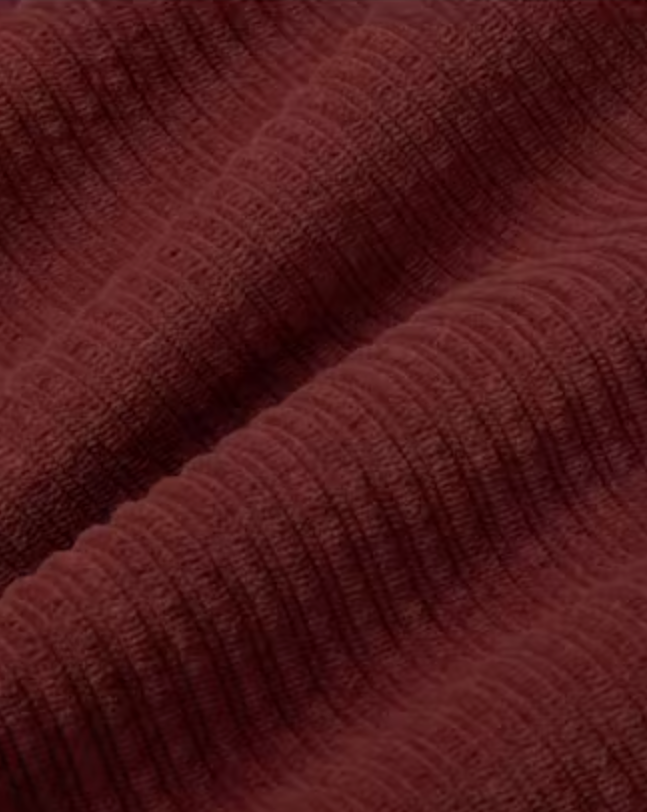 Mahagonifarbene Cordhose "Hedda" aus 100% Bio-Baumwolle mit geradem Bein und aufgesetzten Taschen vor hellem Hintergrund.