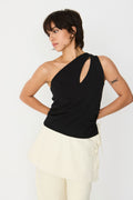 Model trägt das schwarze Kris-Gots T-Shirt der Marke SKFK im One-Shoulder-Stil mit Keyhole-Ausschnitt zu einem hellen Rock.