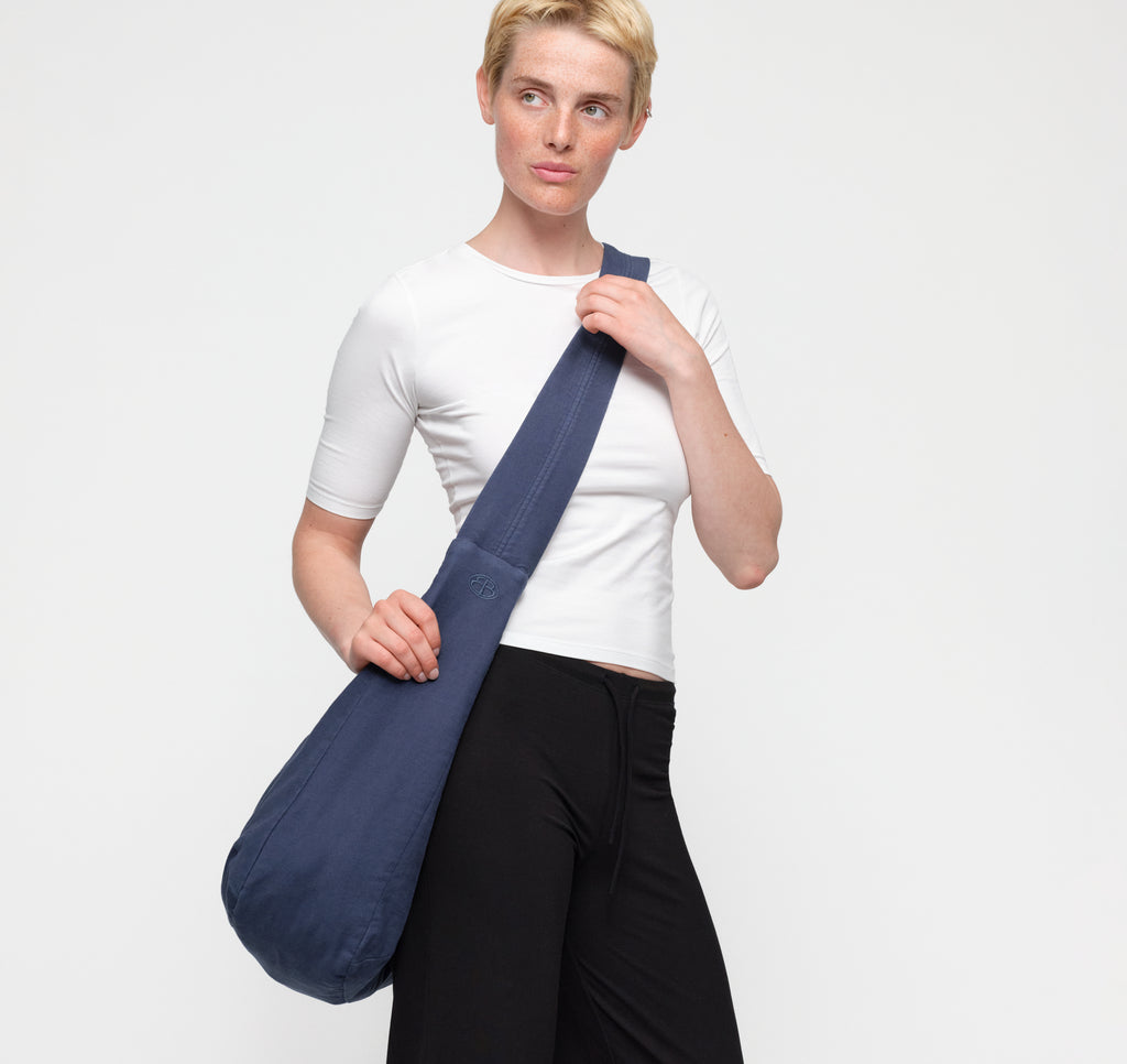 Model trägt die dunkelblaue Alley Copenhagen Shoulder Bag lässig über der Schulter vor hellem Hintergrund.
