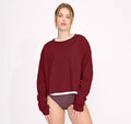 Model trägt ein cranberry-farbenes Reset Cropped Long Sleeve aus Bio-Baumwolle mit Rundhalsausschnitt und leicht überschnittenen Schultern.