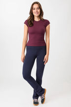 Person von vorne in einem dunkelroten, gerippten Slim-Fit-T-Shirt mit kurzen Ärmeln und Raglanschnitt vor hellem Hintergrund.