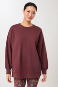 Person von vorne in einem rosewoodfarbenen Oversized-Sweatshirt „Sweattie“ mit Rundhalsausschnitt vor hellem Hintergrund.