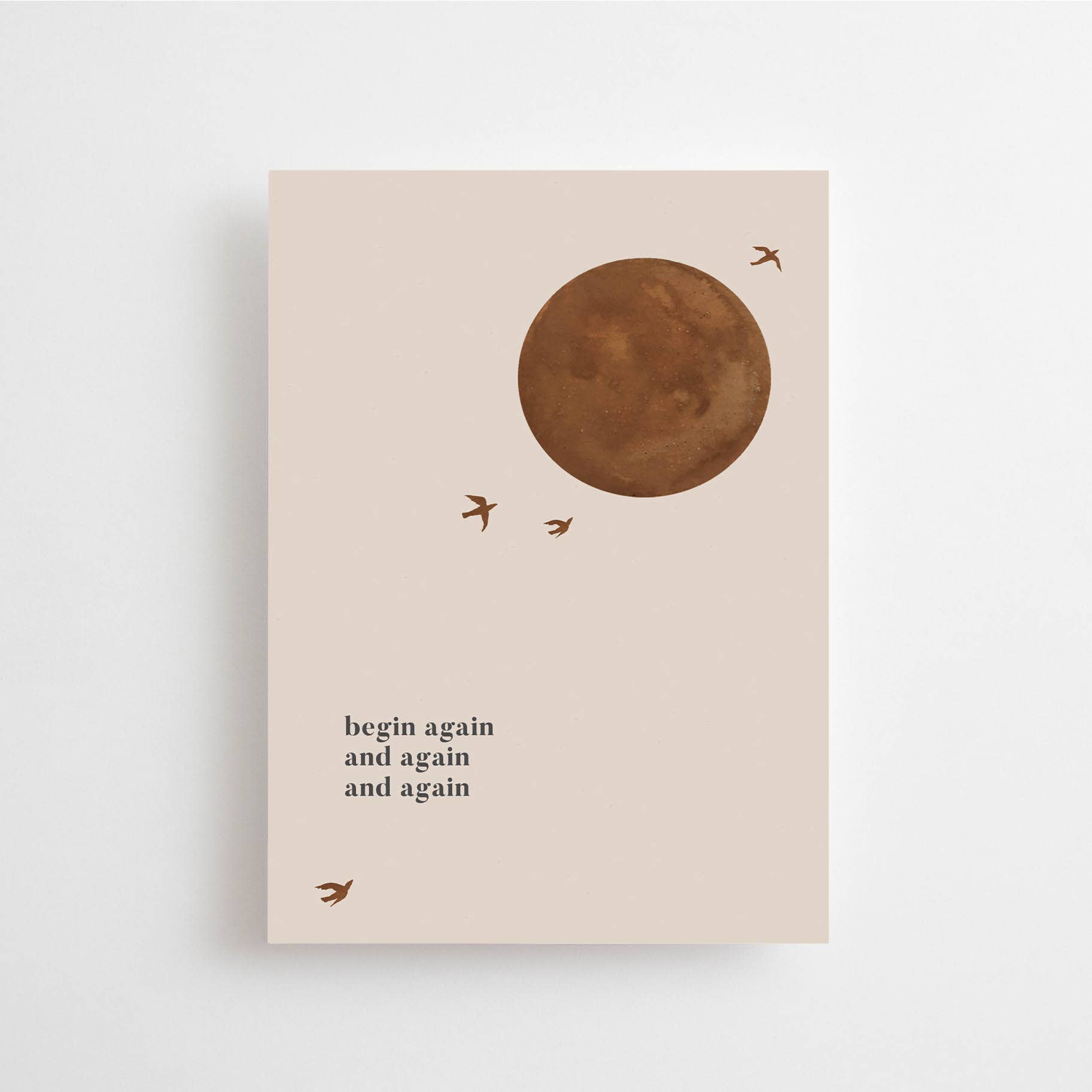 Postkarte "Begin Again" im DIN A6 Format von Anna Cosma mit einem runden braunen Motiv, kleineren Vögeln und dem Text "begin again and again and again" auf beigem Hintergrund.