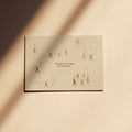 Postkarte "Dance" im DIN-A6-Format von Anna Cosma mit tanzenden, filigranen Figuren, kleinen Sternen und dem Text „Maybe it's all part of the dance...“ auf einem warmen, strukturierten Naturpapier-Hintergrund.