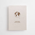 Postkarte "Love your Local Planet" im DIN-A6-Format von Anna Cosma aus strukturiertem Graspapier mit einer braunen Illustration der Erde und kleinen Sternen.