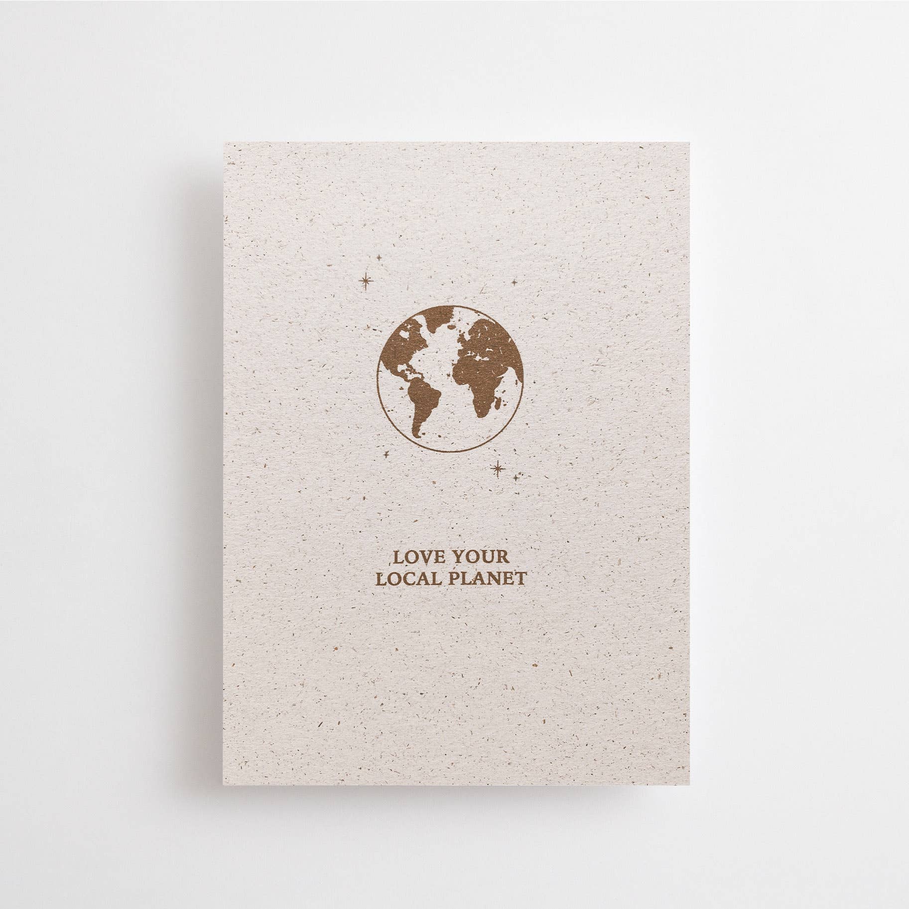 Postkarte "Love your Local Planet" im DIN-A6-Format von Anna Cosma aus strukturiertem Graspapier mit einer braunen Illustration der Erde und kleinen Sternen.