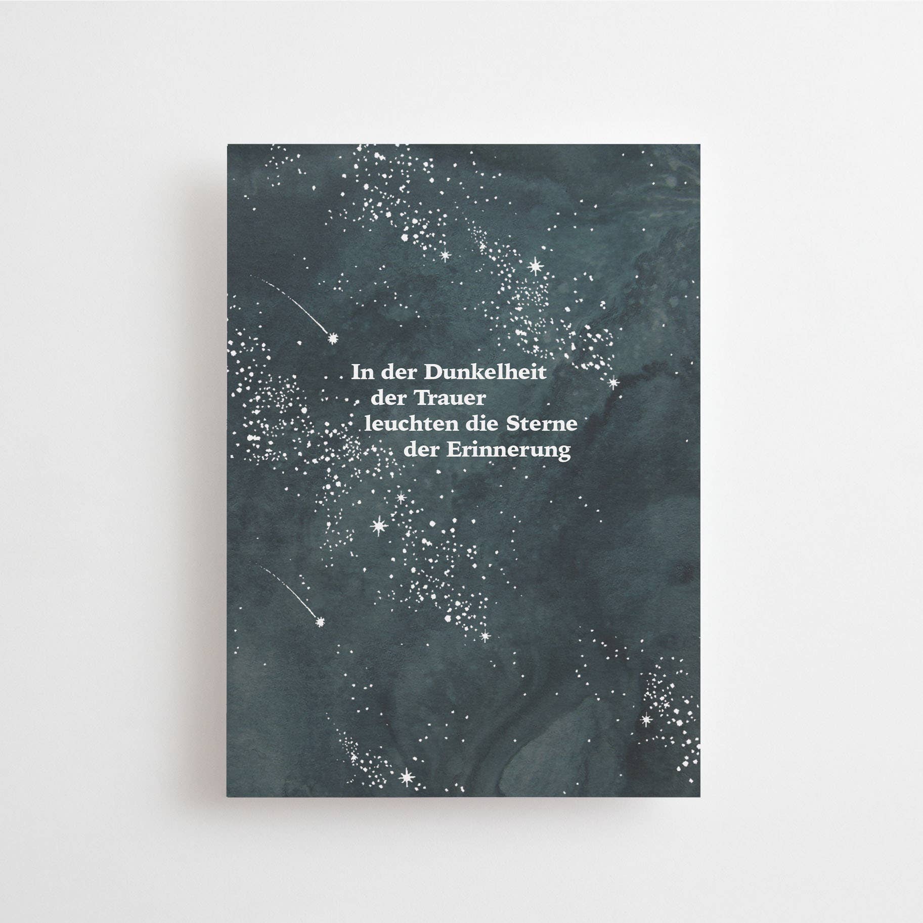 Postkarte „Sterne der Erinnerung“ im DIN-A6-Format mit einem dunklen Sternenhimmel-Design und dem weißen Schriftzug vor hellem Hintergrund.
