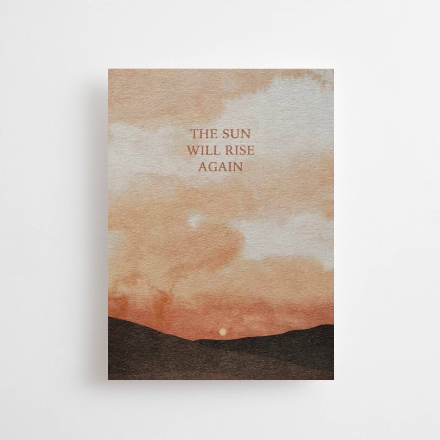 Postkarte „The Sun will Rise again“ im DIN-A6-Format mit einer warmen Sonnen-Illustration über dunklen Hügeln und dem Schriftzug vor hellem Hintergrund.