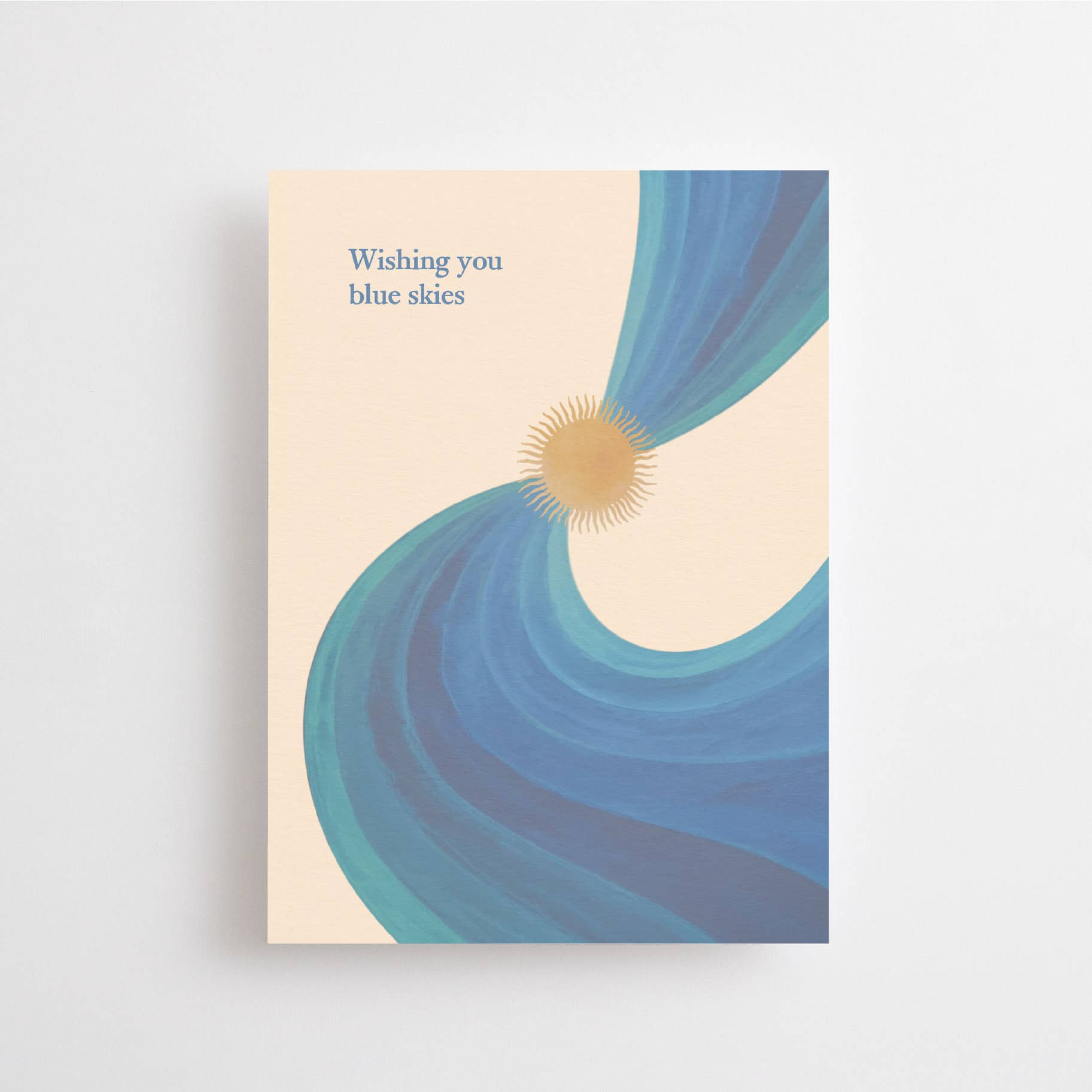Postkarte „Wishing you Blue Skies“ im DIN-A6-Format mit einer warmen Sonne, fließenden blauen Wellenlinien und dem Schriftzug vor hellem Hintergrund.