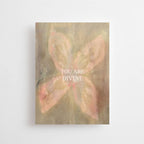Postkarte "You are Divine" im DIN-A6-Format von Anna Cosma mit einem abstrakten, blütenartigen Motiv in sanften Naturtönen und dem weißen Text „YOU ARE DIVINE“.
