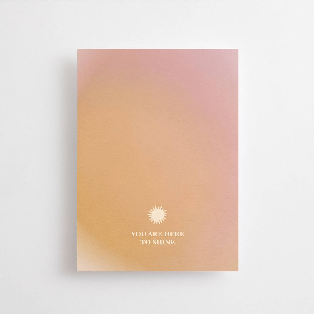 Postkarte „You are Here to Shine“ im DIN-A6-Format mit einem Farbverlauf in warmen Tönen, einer kleinen Sonne und dem Schriftzug vor hellem Hintergrund.