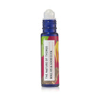 Blauer 10-ml-Roll-On und dazugehörige pinke Umverpackung mit Orangen- und Blatt-Illustrationen vor einem grünen Hintergrund.