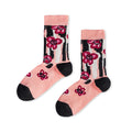 Rosa Socken „Classic not Boring“ mit einem schwarz-weißen Streifen- und Blumenmuster, pinken Blüten sowie schwarzen Akzenten an Spitze und Ferse vor hellem Hintergrund.