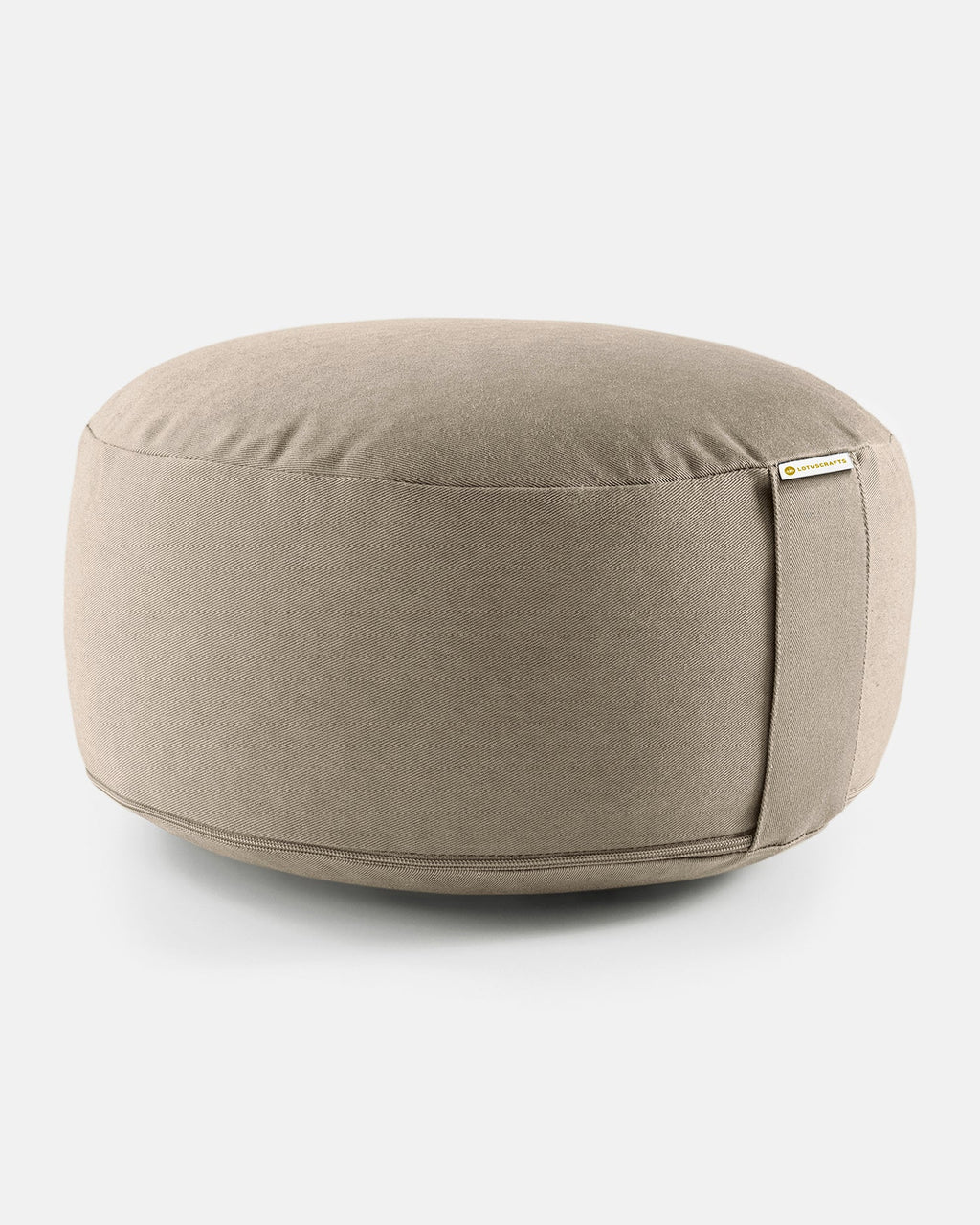 Rundes Meditationskissen in Light Taupe mit seitlicher Lasche vor hellem Hintergrund.