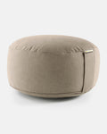 Rundes Meditationskissen in Light Taupe mit seitlicher Lasche vor hellem Hintergrund.