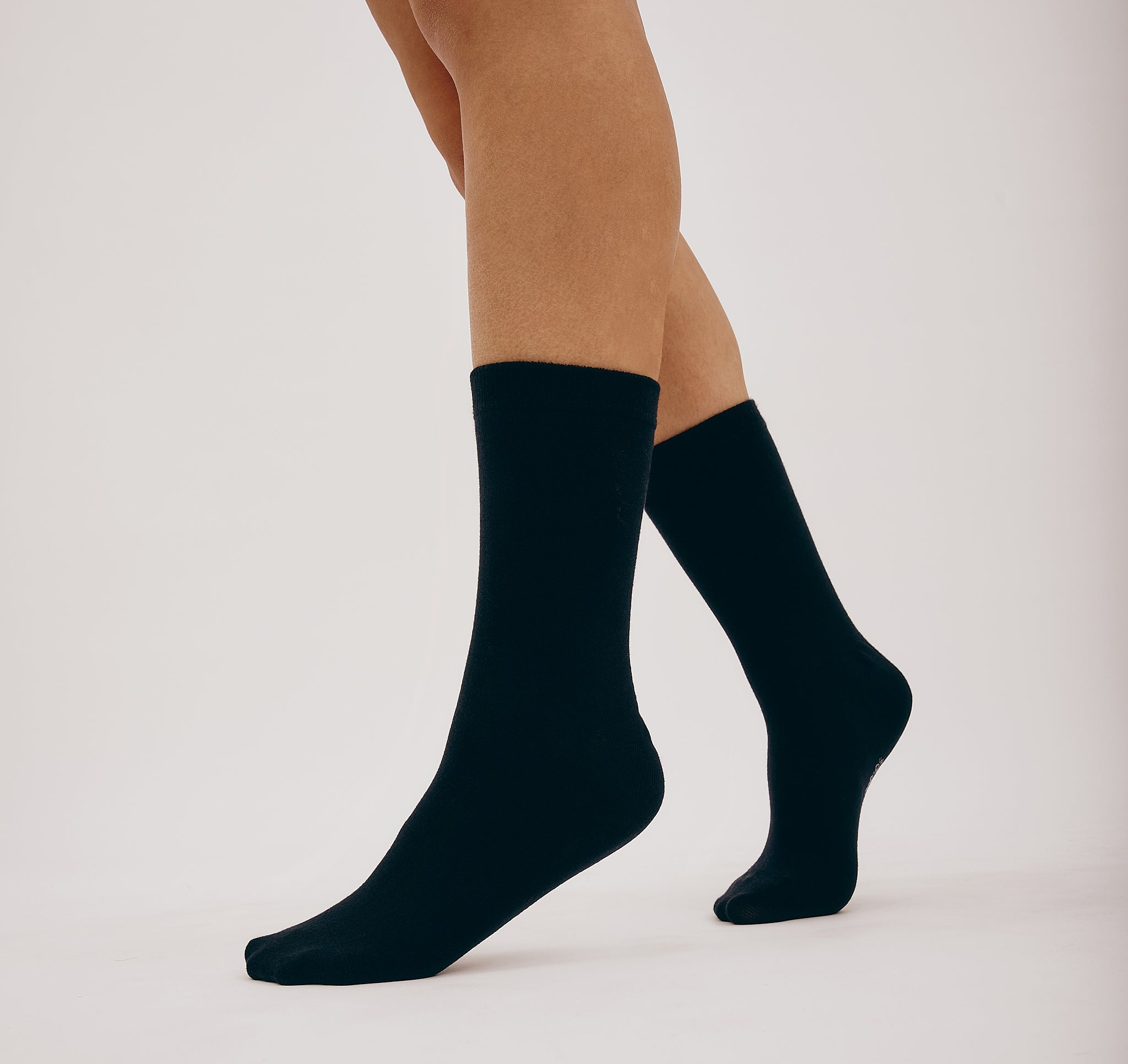Schwarze Core Crew Socks in klassischer Crew-Länge an den Beinen eines Modells vor hellem Hintergrund.