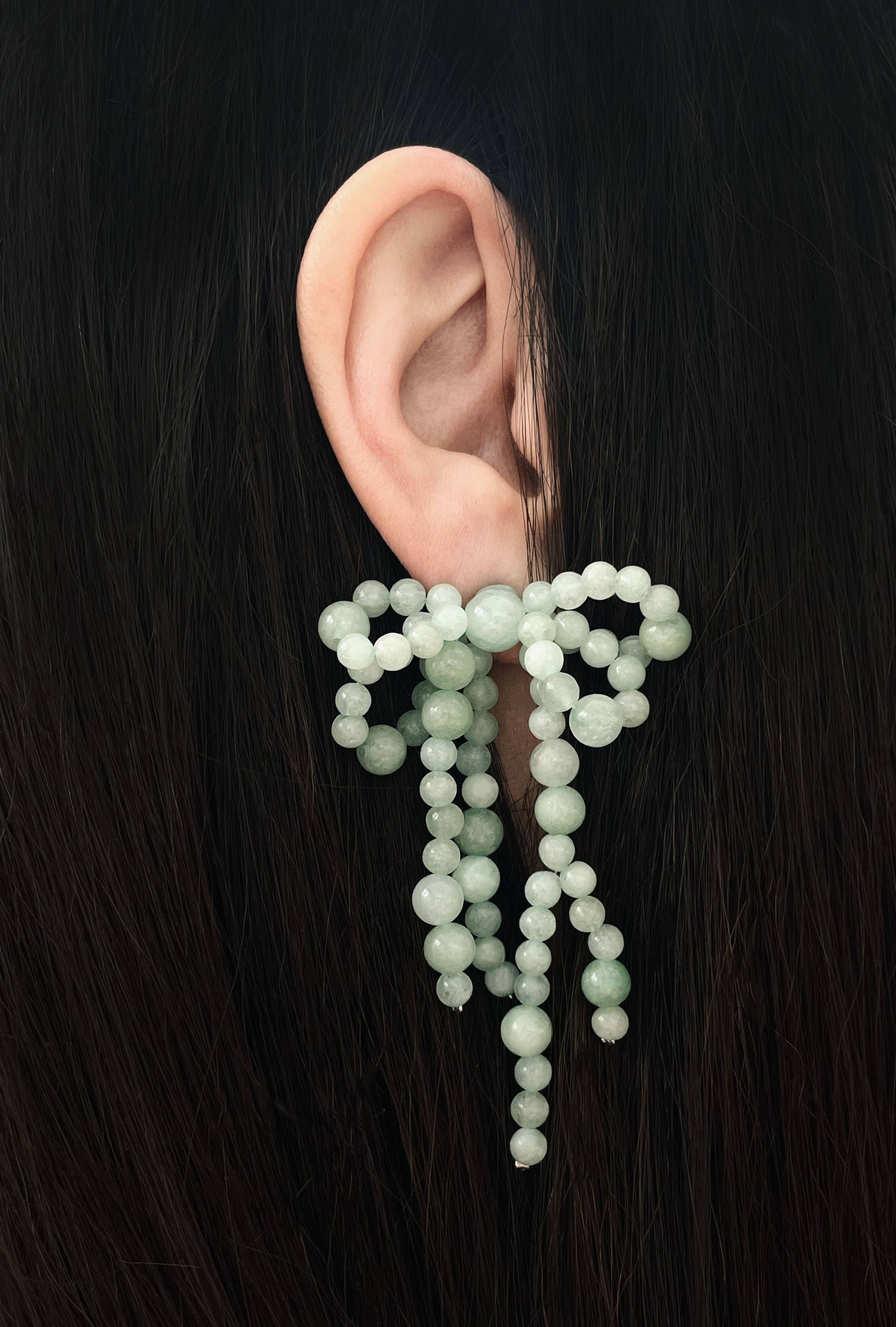 Tragebeispiel der Achat-Schleifen-Ohrstecker in der Farbe See (Jade-Grün) an einem Modell.