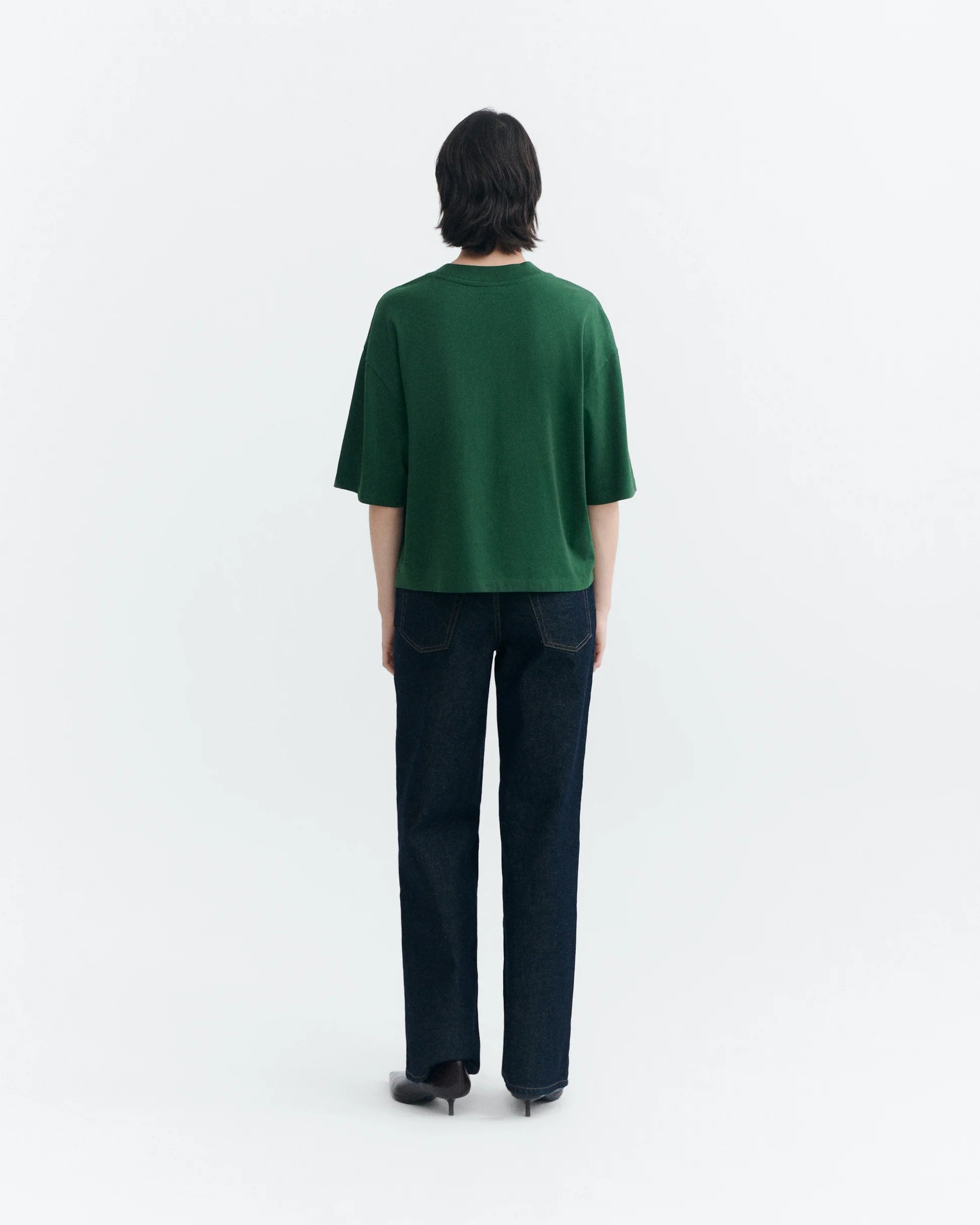 Person von vorne in einem grünen Oversized-T-Shirt "Lena" von Thinking Mu mit Rundhalsausschnitt vor hellem Hintergrund.